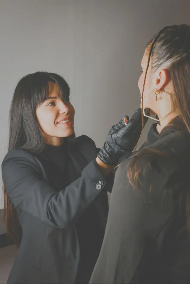 Hair colorist smiling while applying color for a client