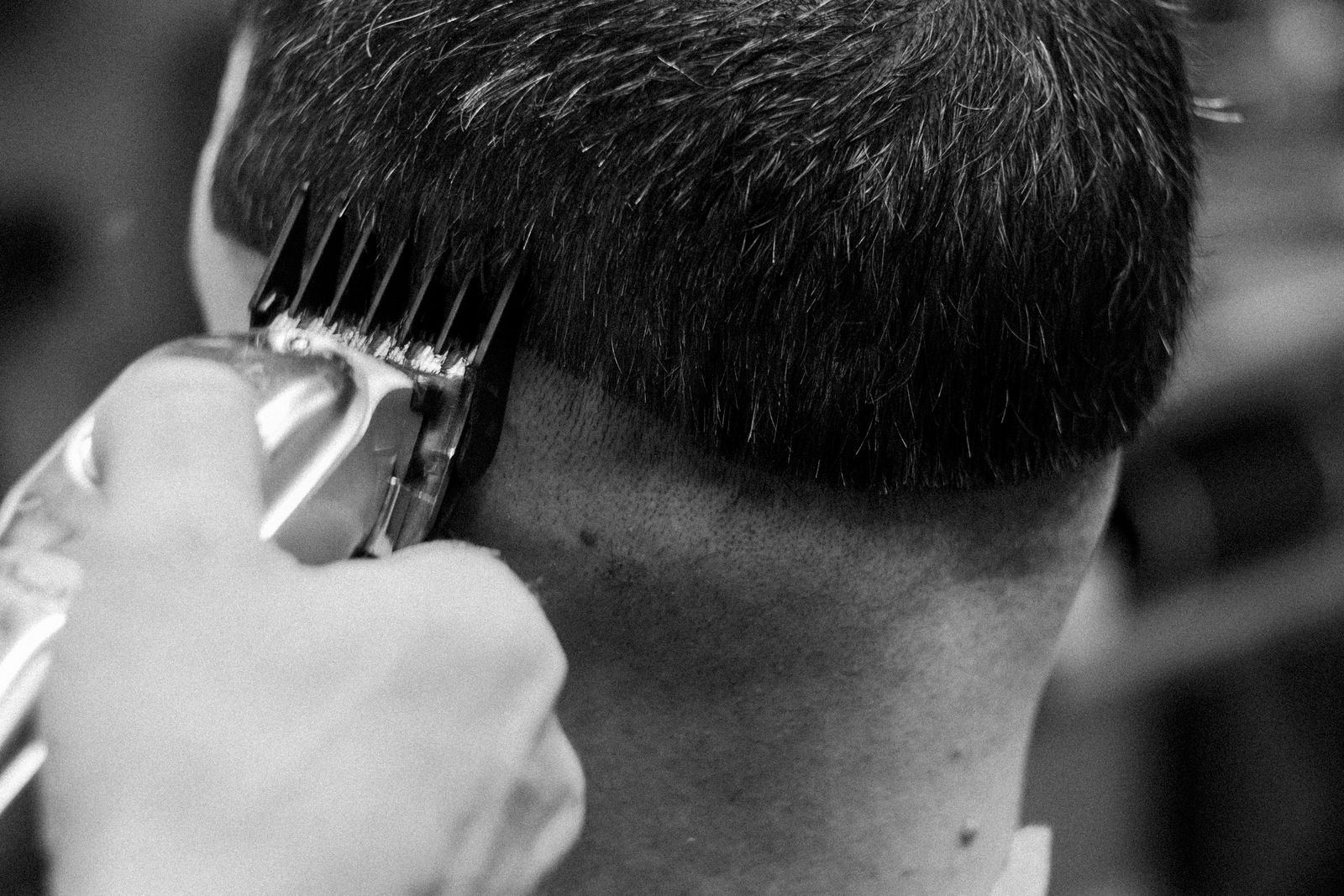 Barber working clippers along a client's neckline