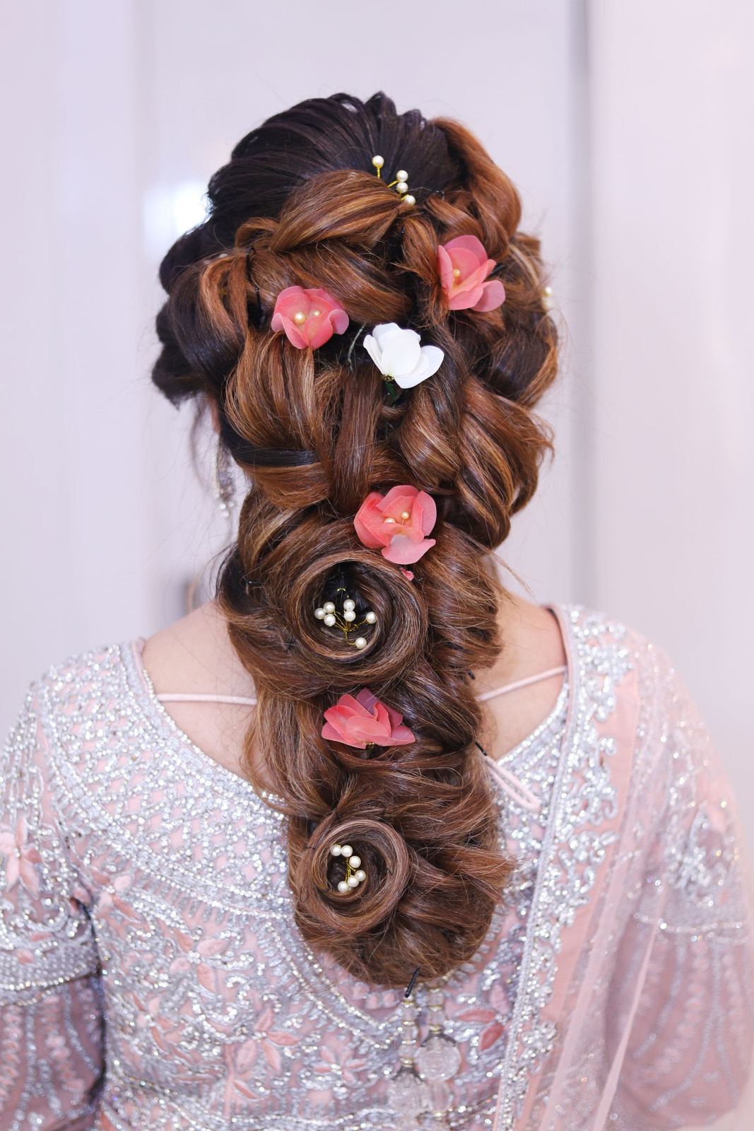 Braided updo with pink flowers and pearls