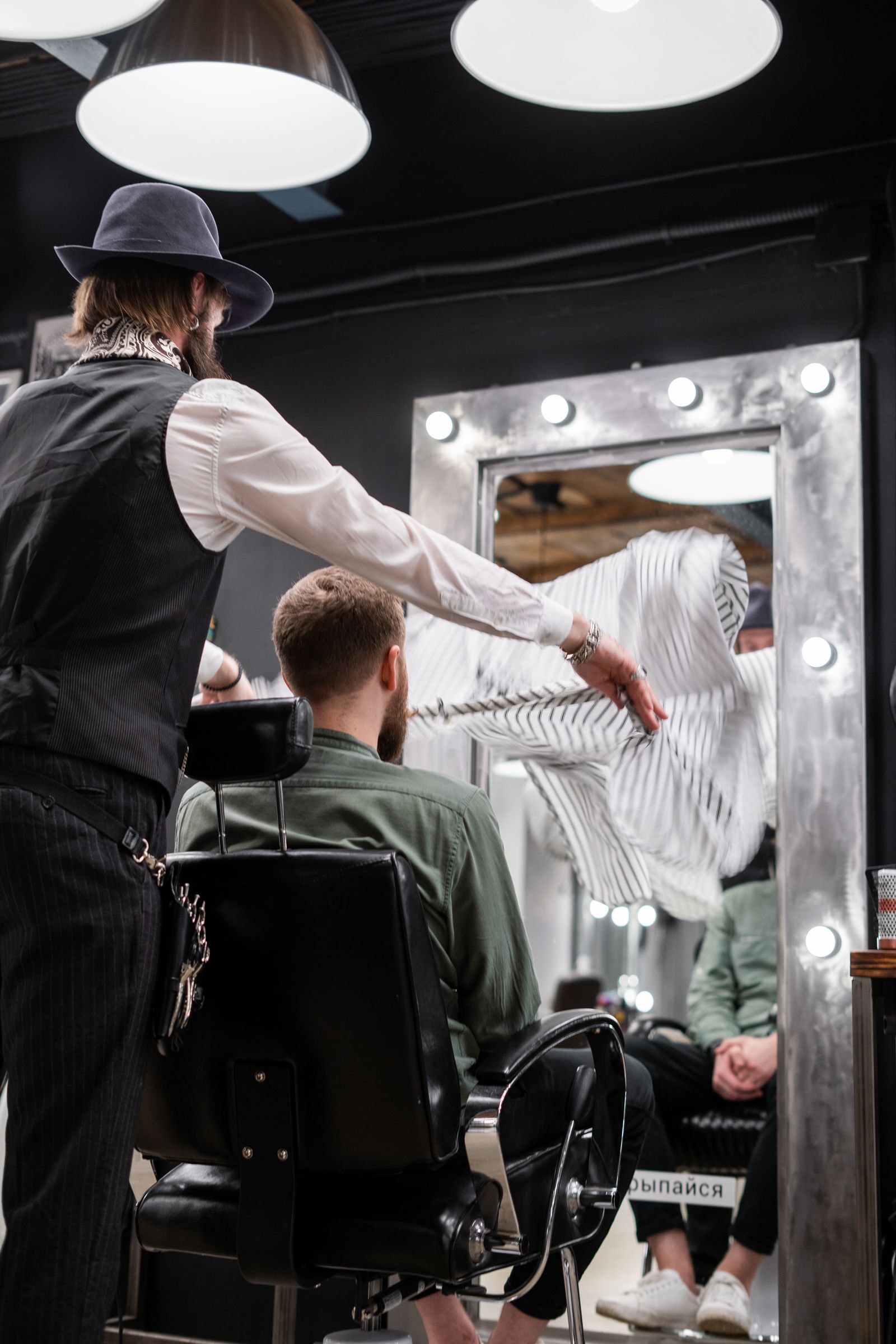 Walt Gentry in a fedora and waistcoat caping a client