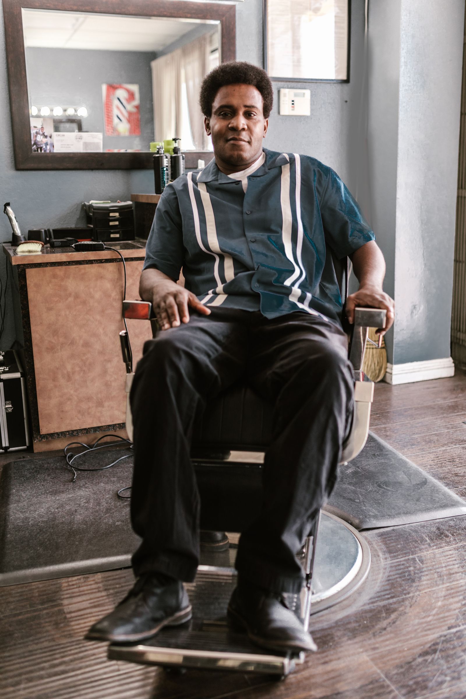 Marcus Bell seated in a vintage barber chair