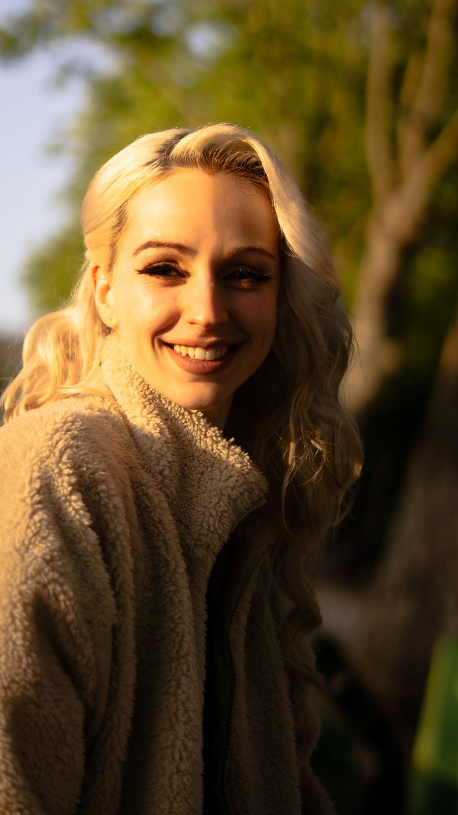 Lainey Brooks, colorist and owner of Honey and Hue, smiling in warm evening light