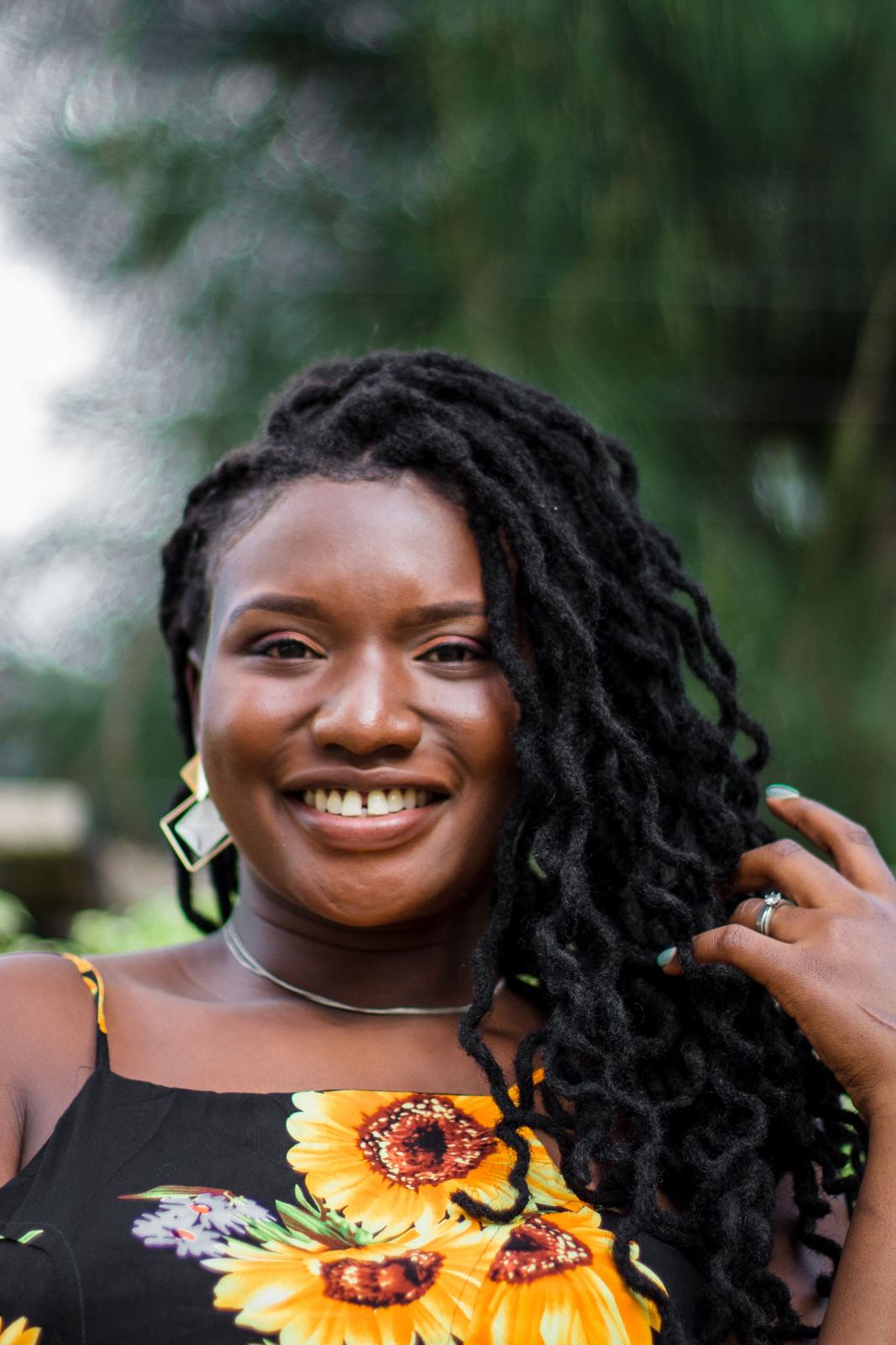 Woman with long locs laughing outdoors