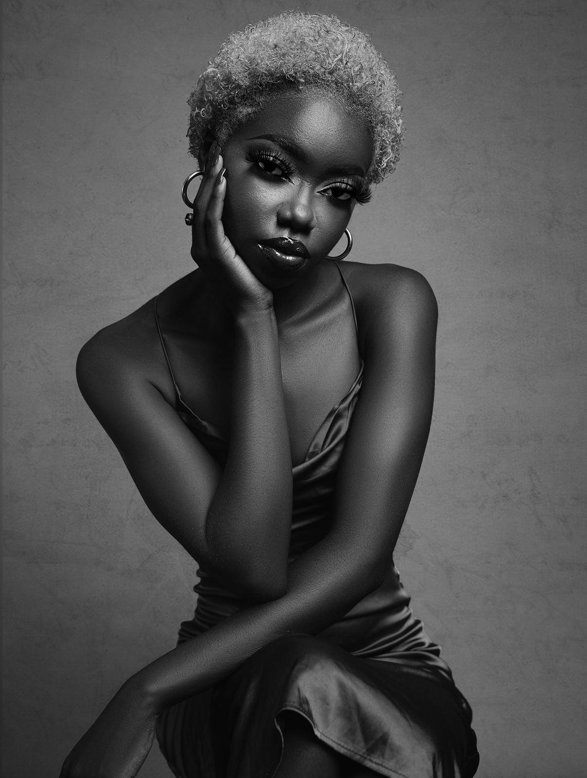 Client with a short sculpted coily cut, black and white portrait