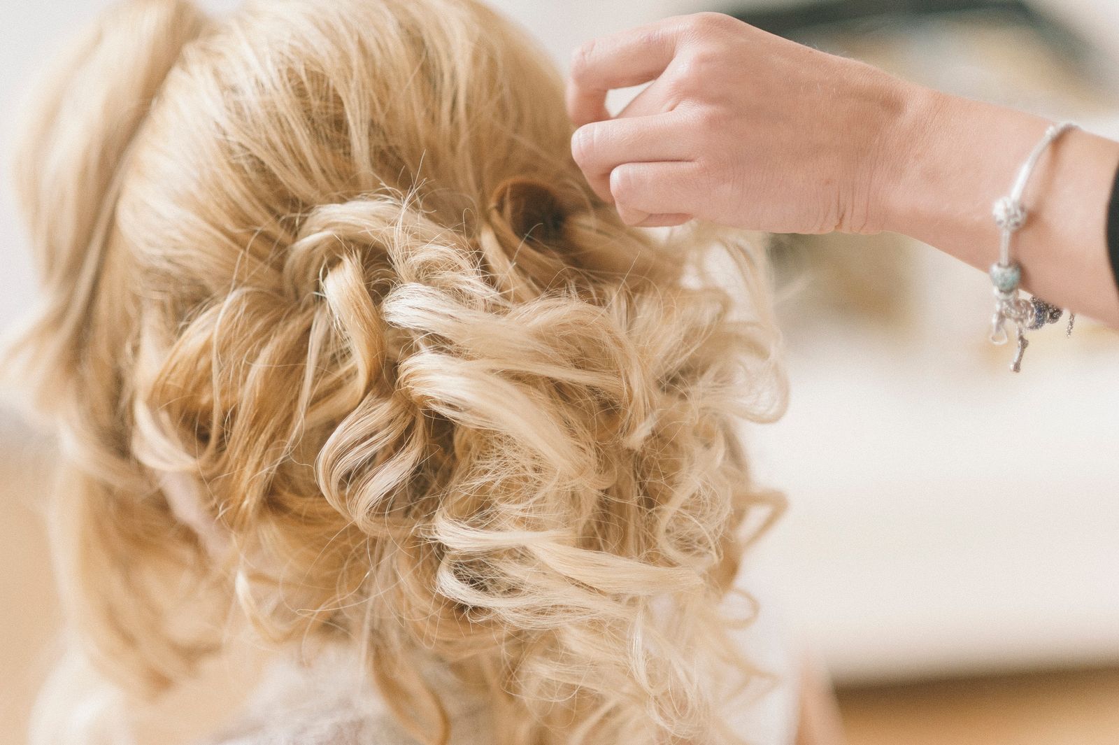 After: a soft, textured bridal updo being finished by hand