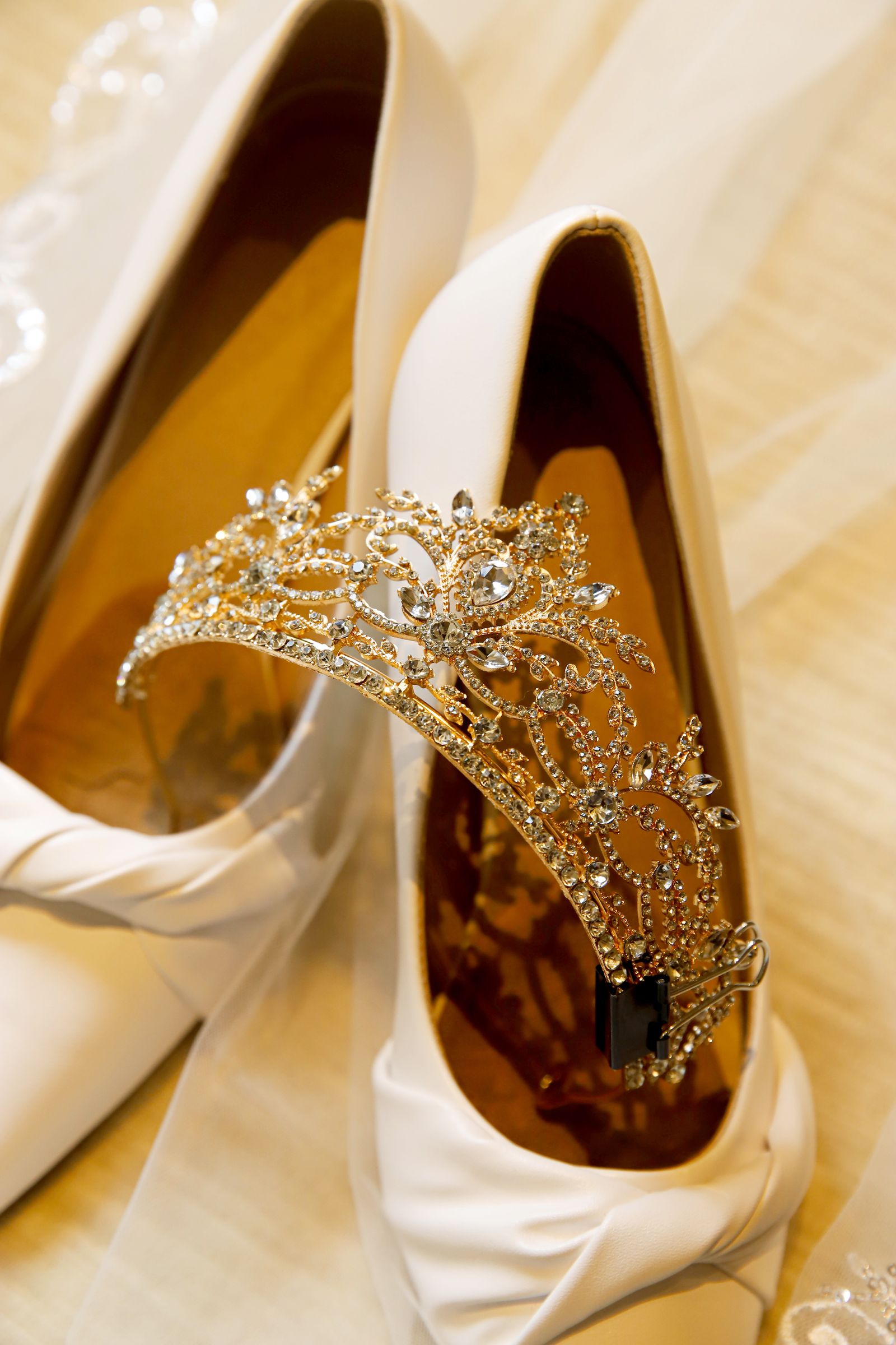 Crystal tiara resting in ivory bridal heels