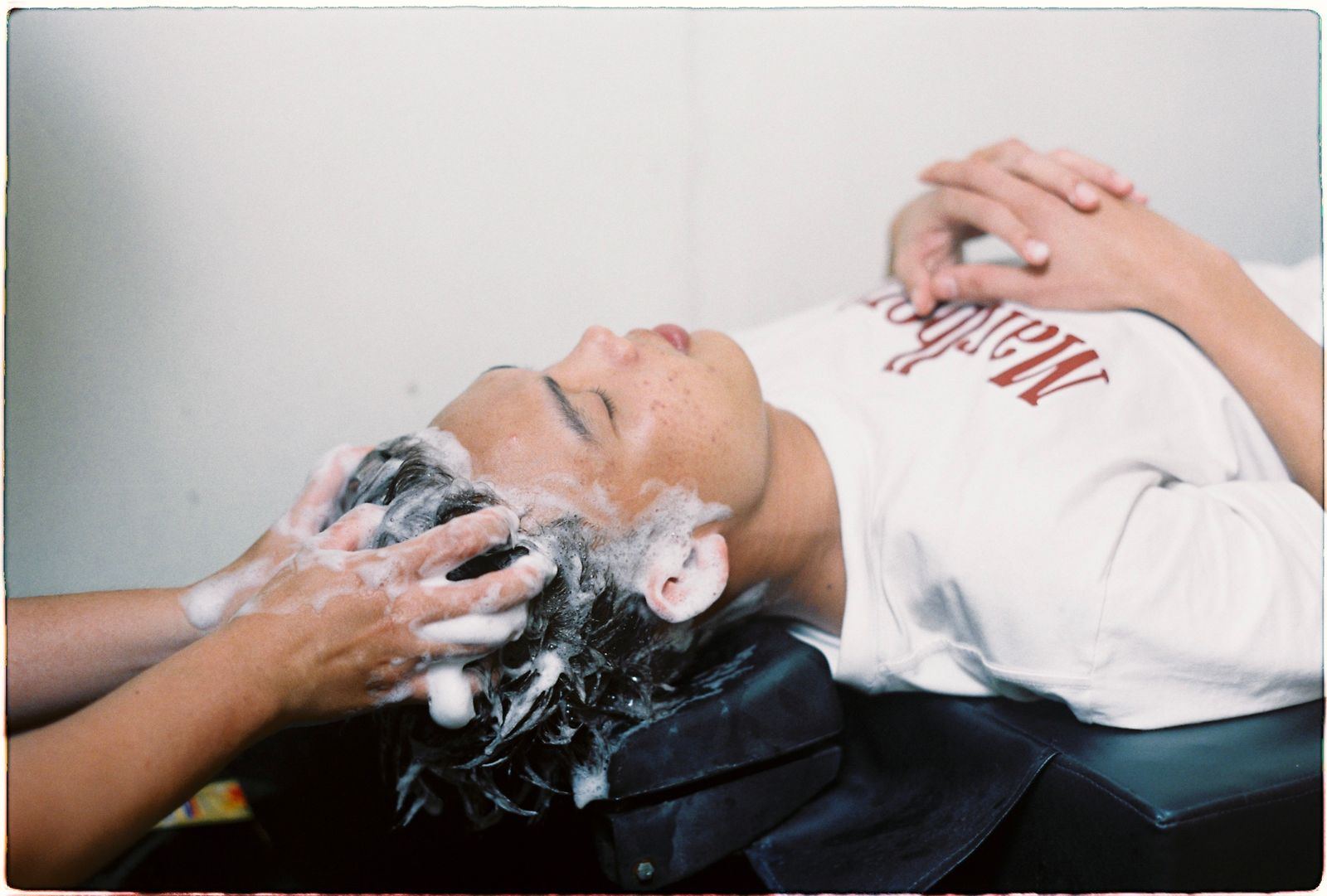 Client getting a shampoo and scalp massage at the wash station