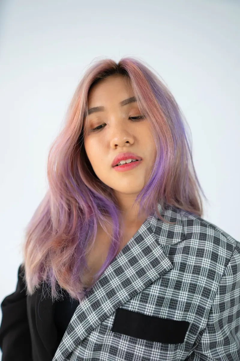 Stylish portrait of a woman in Jakarta with lavender hair and a checkered blazer.