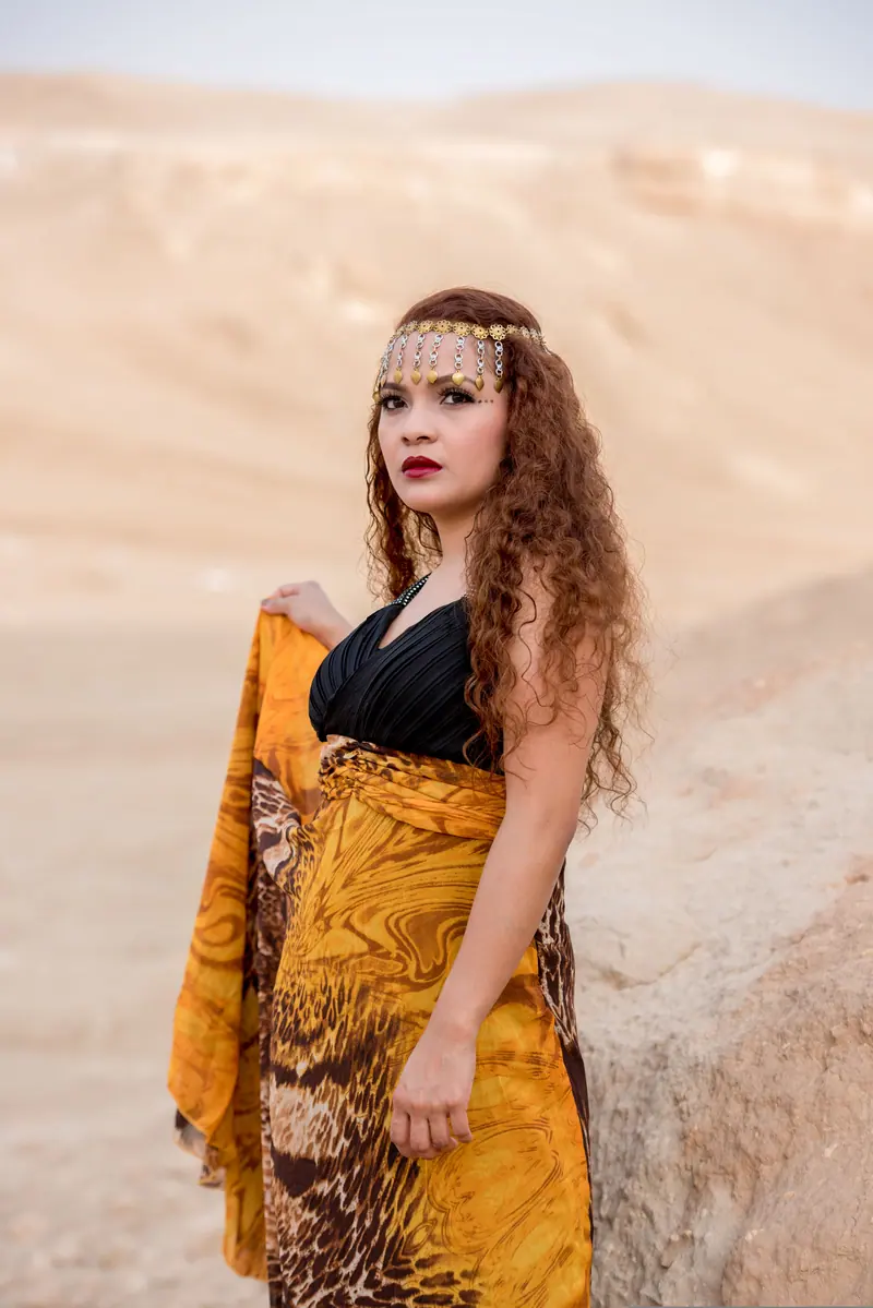 A woman in elegant traditional attire stands outdoors, exuding grace and style.