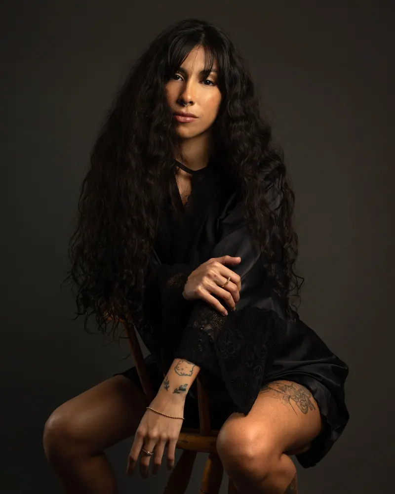Fashion portrait of a woman with long black hair and tattoos in a studio setting, Rio de Janeiro.