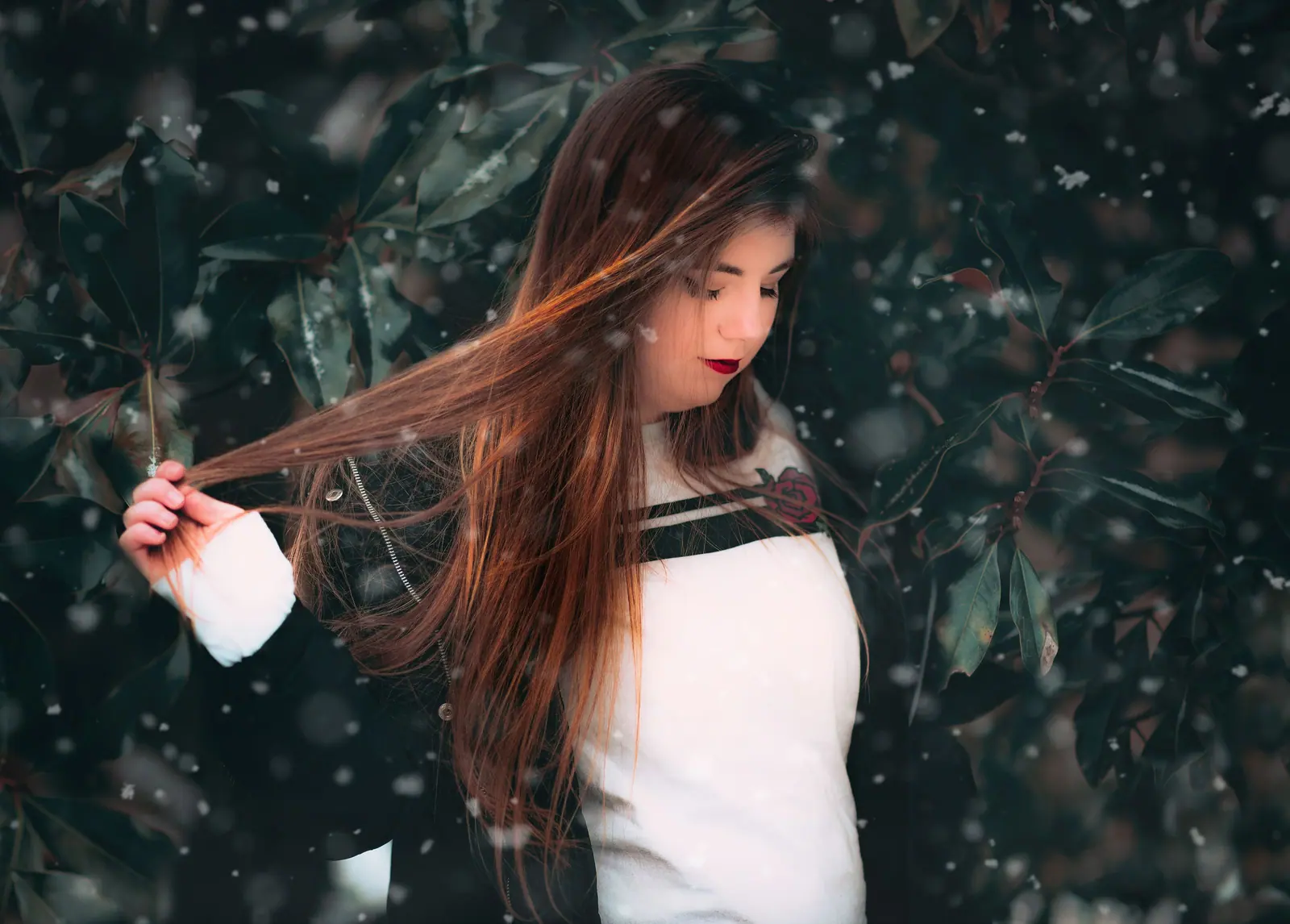 Portrait of a young woman with long hair outdoors in a snowy setting, expressing elegance and style.