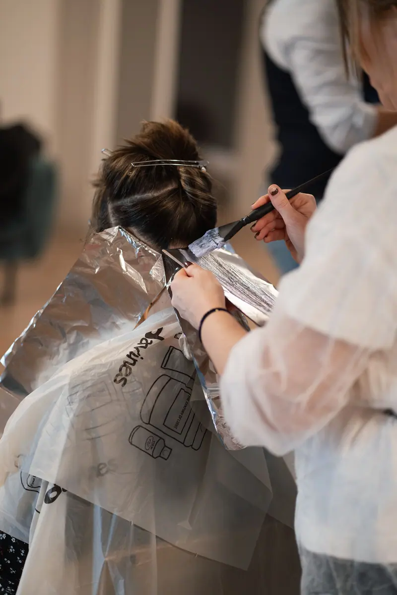 Colorist painting foils at the back of a client's head