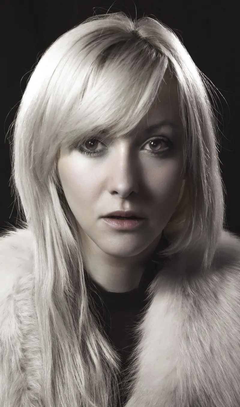 Stunning portrait of a woman with blonde hair in a fur coat, showcasing elegance and style.