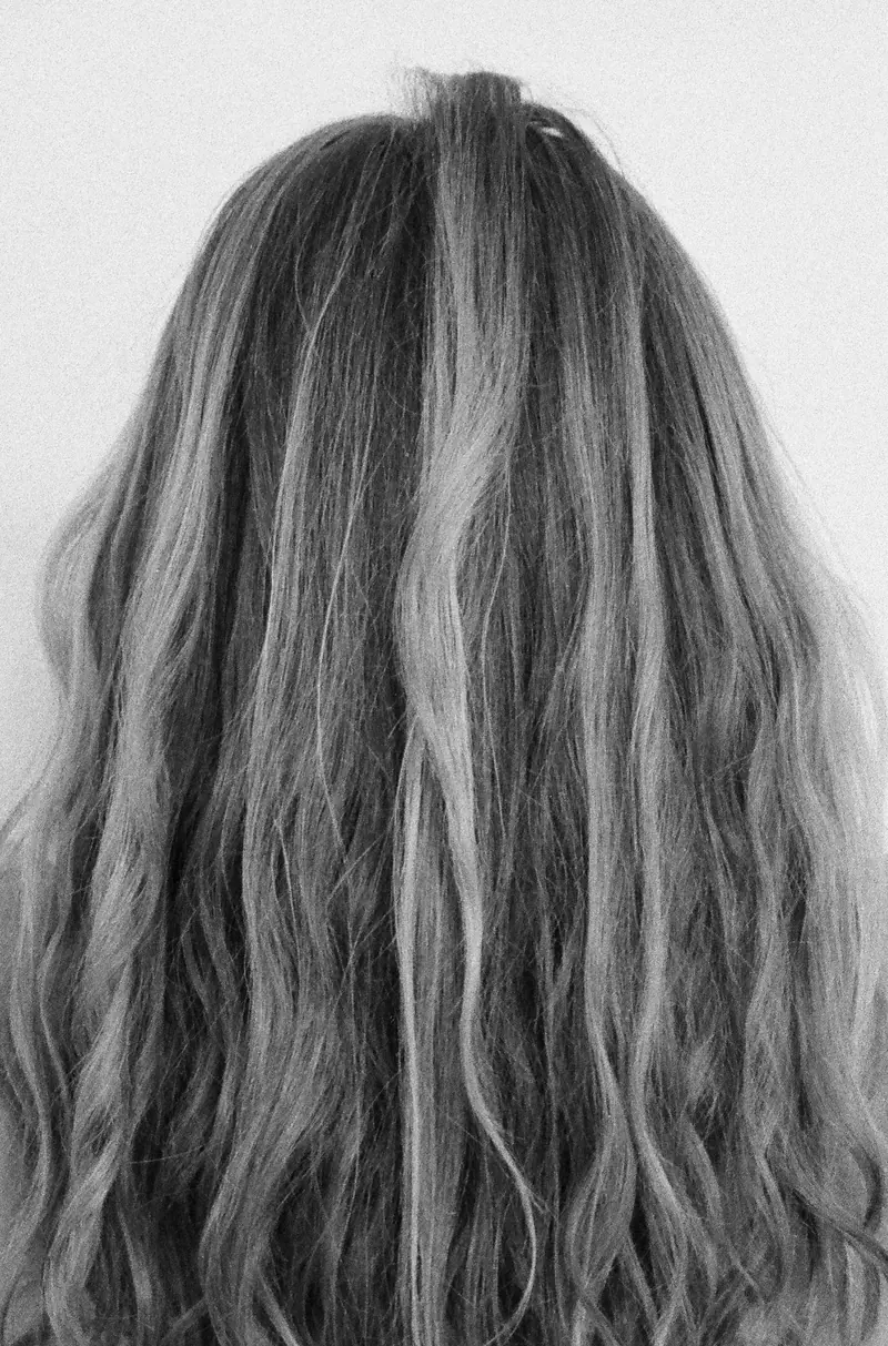 Black and white close-up of long wavy hair, showcasing texture and elegance.