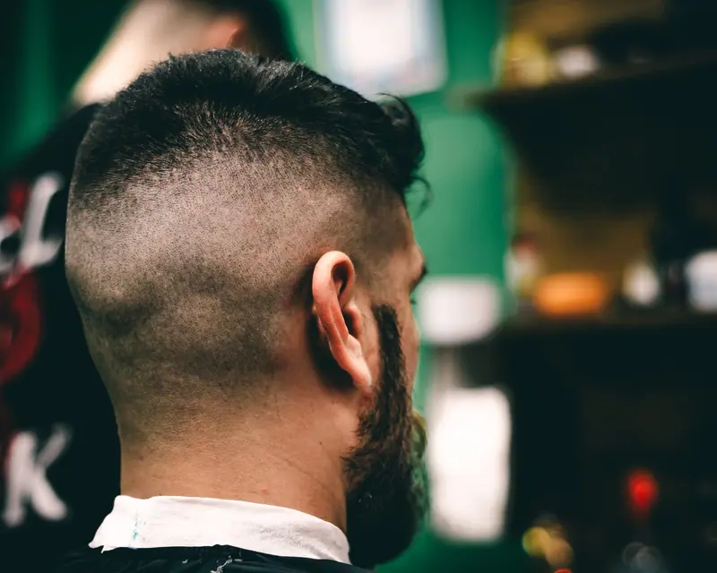 High fade with a full beard, seen from behind