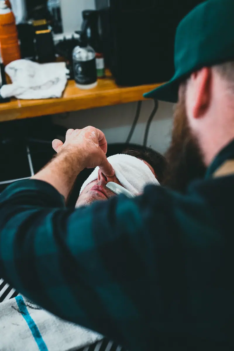 Barber with clippers in low light