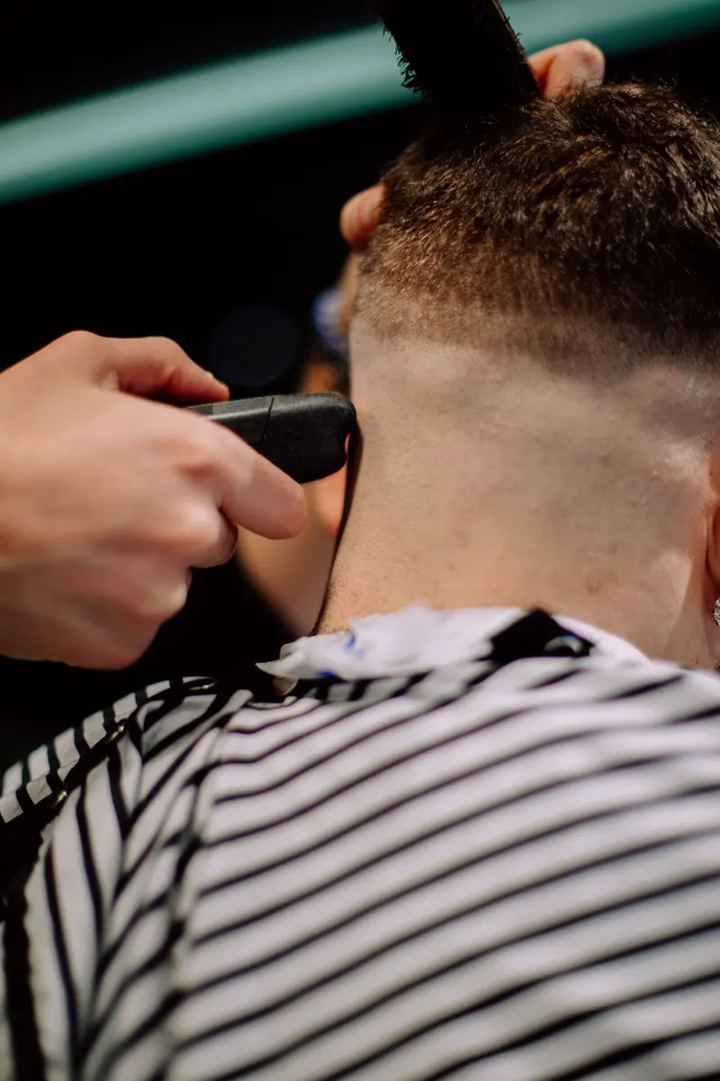 Close-up of a man's haircut in a Geneva barber shop, highlighting skilled hairstyling.