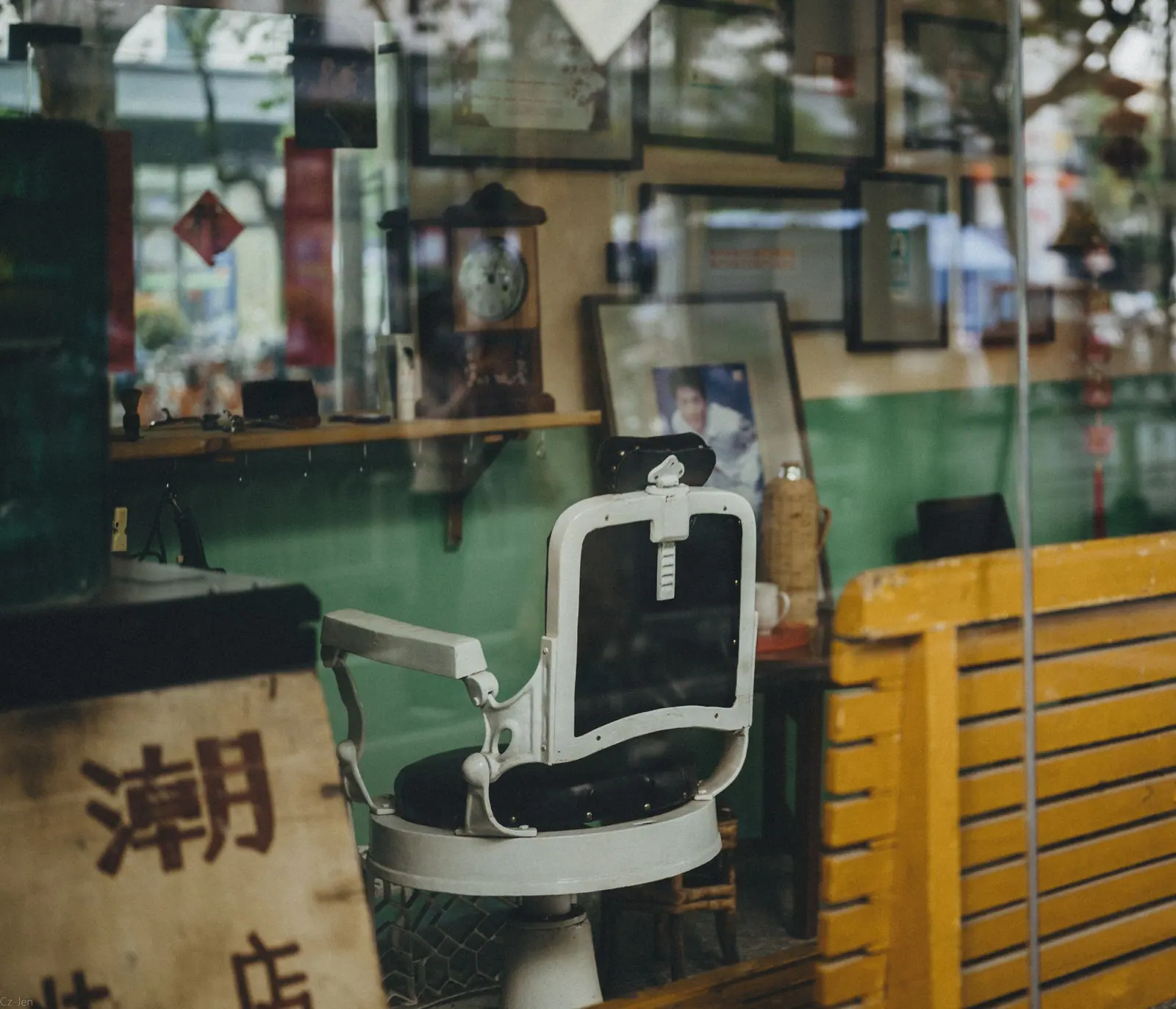 Vintage barber chair in a sunlit, sea-green barbershop with yellow accents