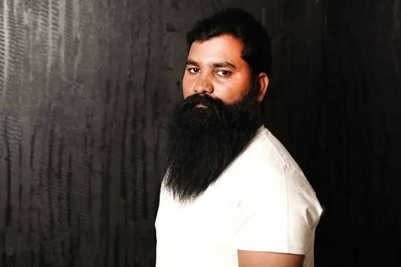 Long black beard on a dark wall