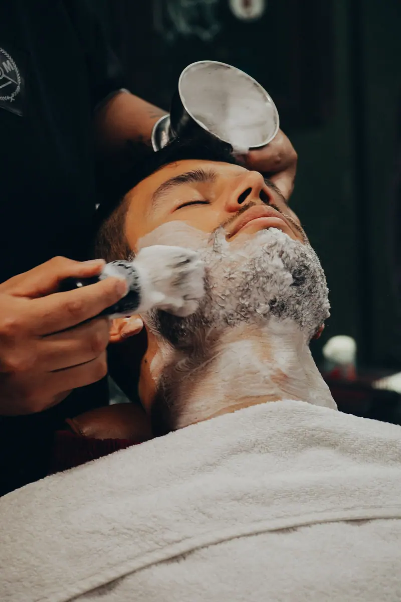 Barber lathering a client for a straight-razor shave