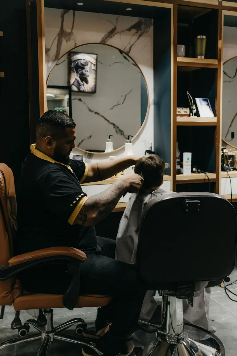 Barber cutting in a dark shop