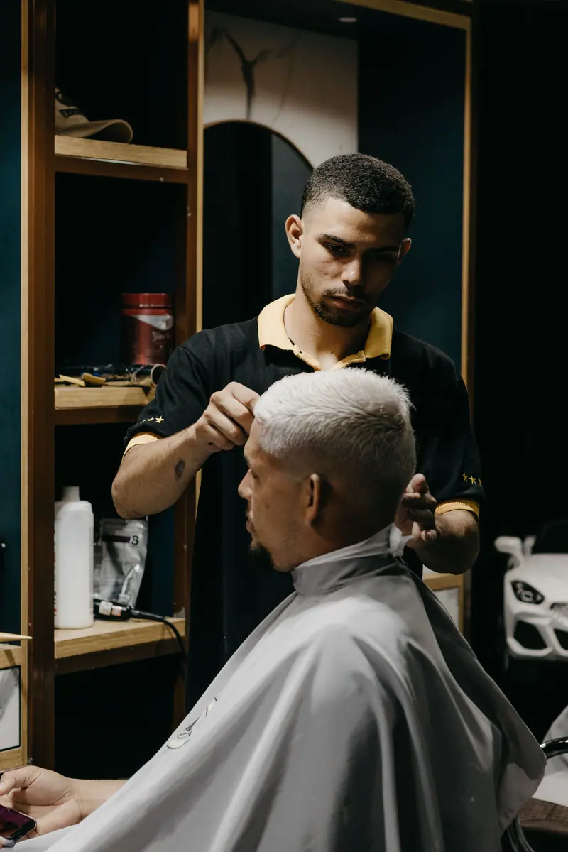 A barber skillfully gives a client a modern haircut in a stylish barbershop setting.