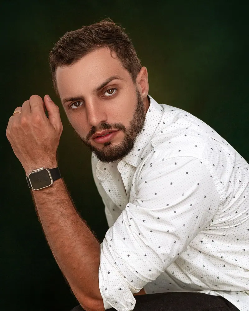 Barber in front of a deep green wall