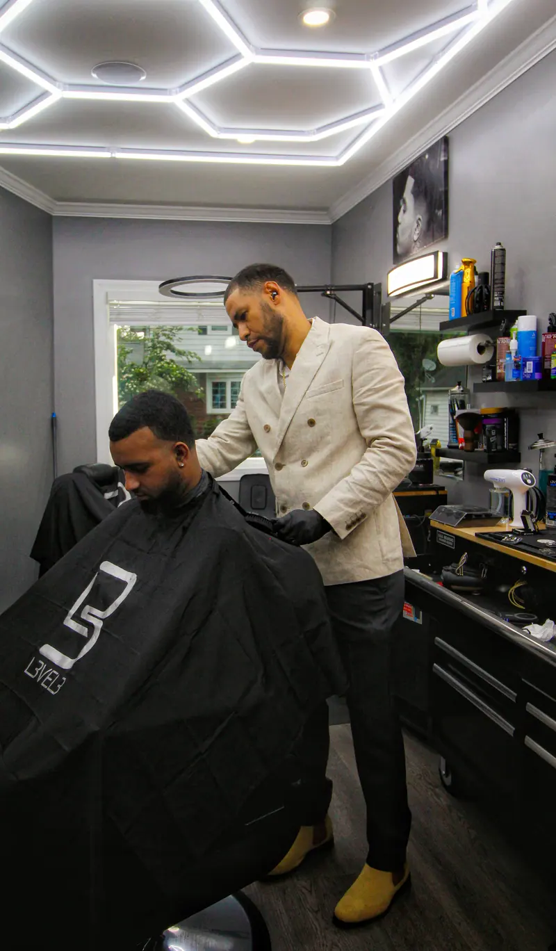 Barber in a cream suit at work
