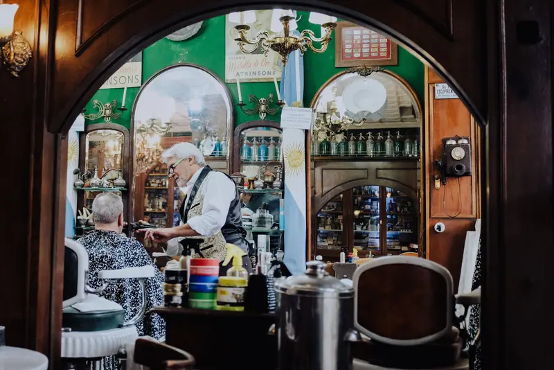 A classic barbershop scene in Buenos Aires, showcasing a retro style interior with a barber at work.