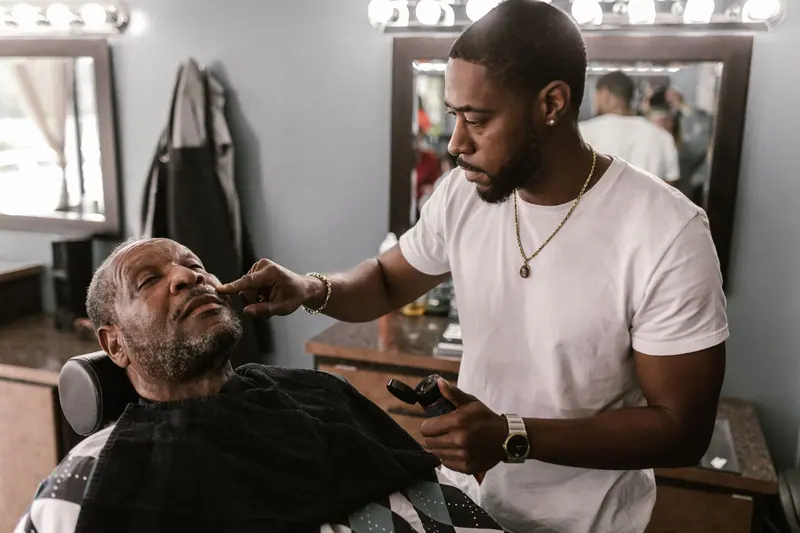 Barber trimming a client's beard