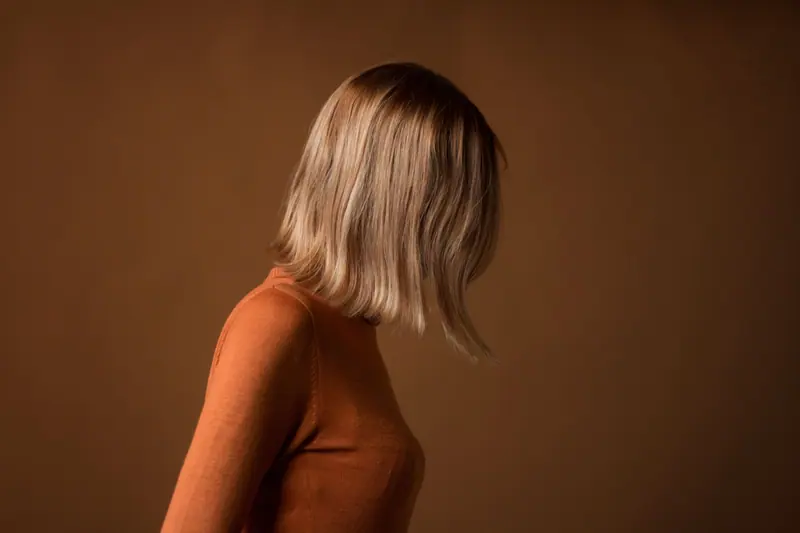 Swinging blonde bob against a warm brown backdrop