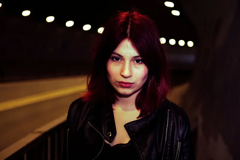 Glossy burgundy hair under string lights at night