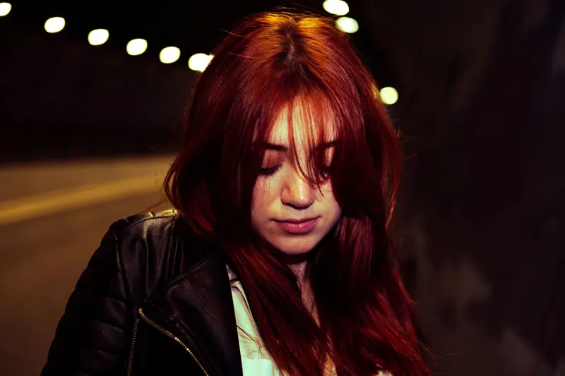 Glossy burgundy hair under string lights