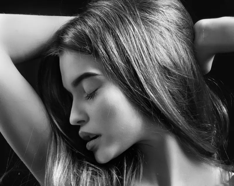 Black-and-white portrait of glossy hair swept back