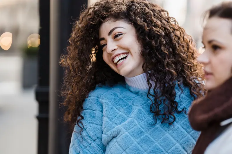 Curly-haired client laughing in the chair