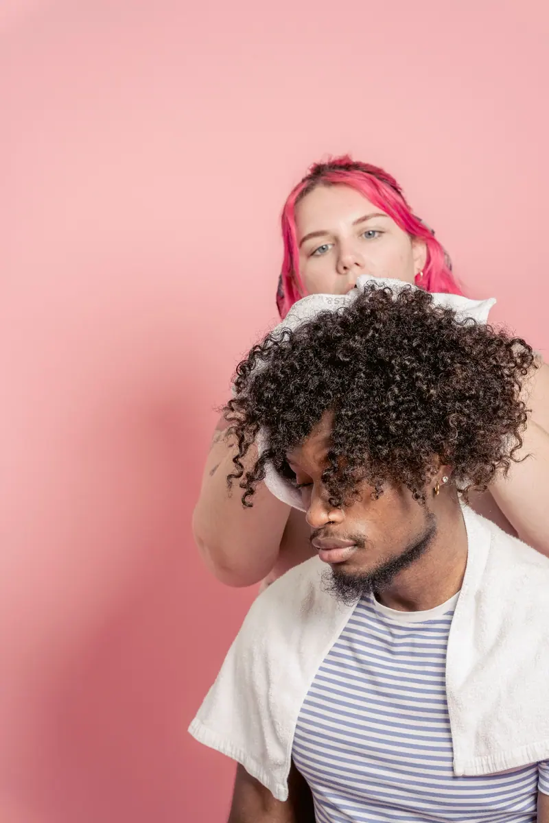 Curly client against a pink wall