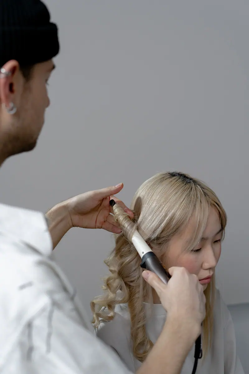 Stylist curling blonde lengths