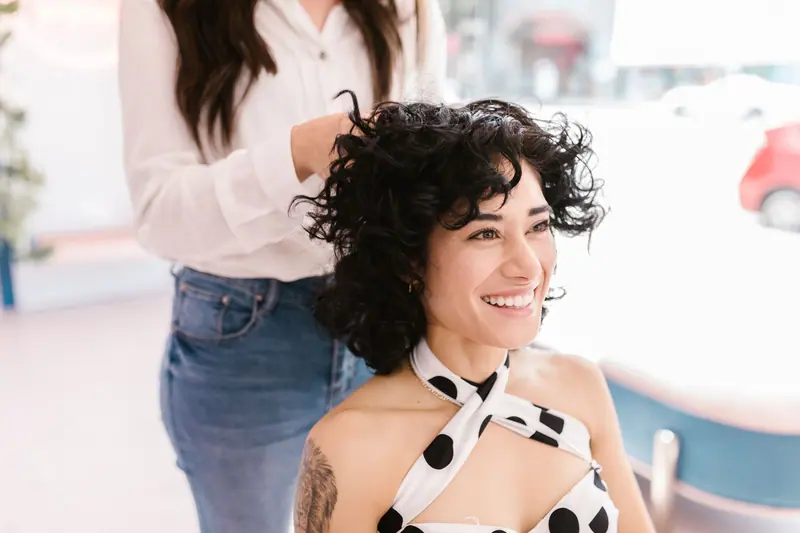 Stylist curling a client's hair