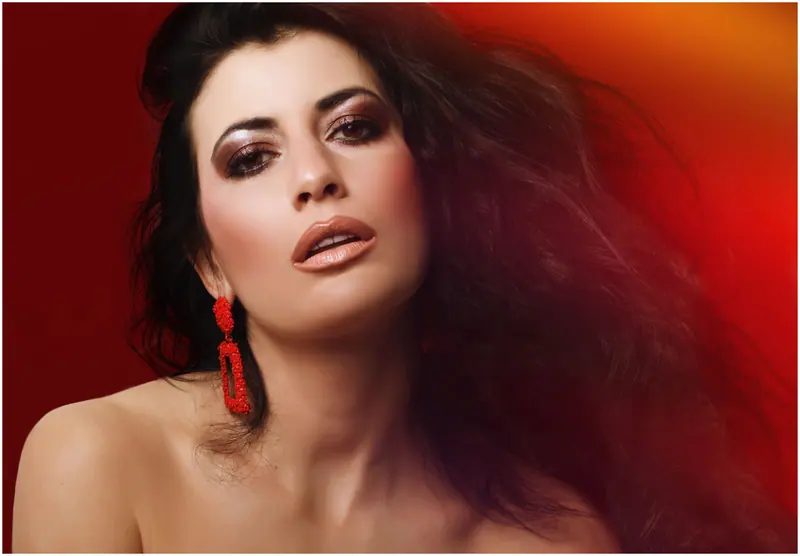 Long dark hair in motion against red