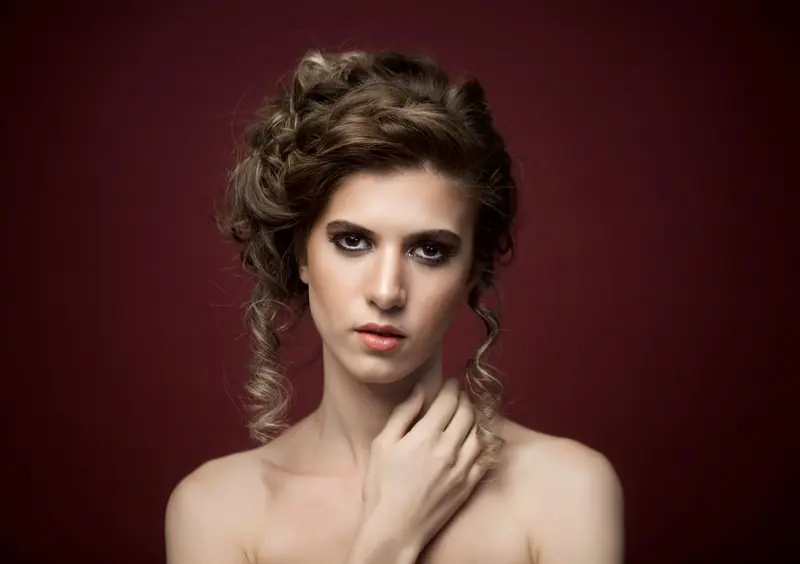Pinned curls against a dark red backdrop