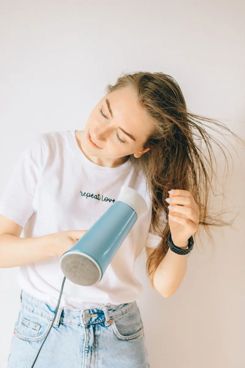 Woman blow-drying long hair at home