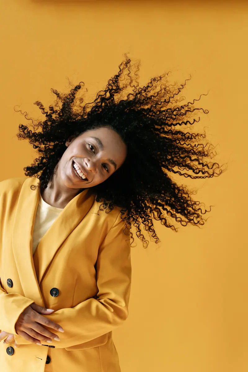 Big curls against a yellow wall