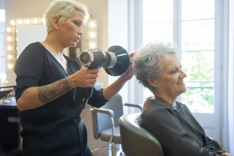Two stylists drying a client