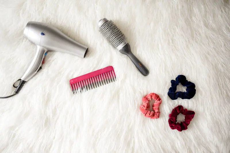 Dryer, brushes and scrunchies on white