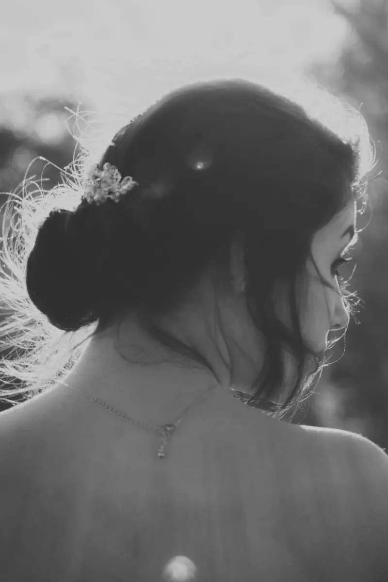 Black and white portrait of a bride in an elegant updo, with romantic lighting.