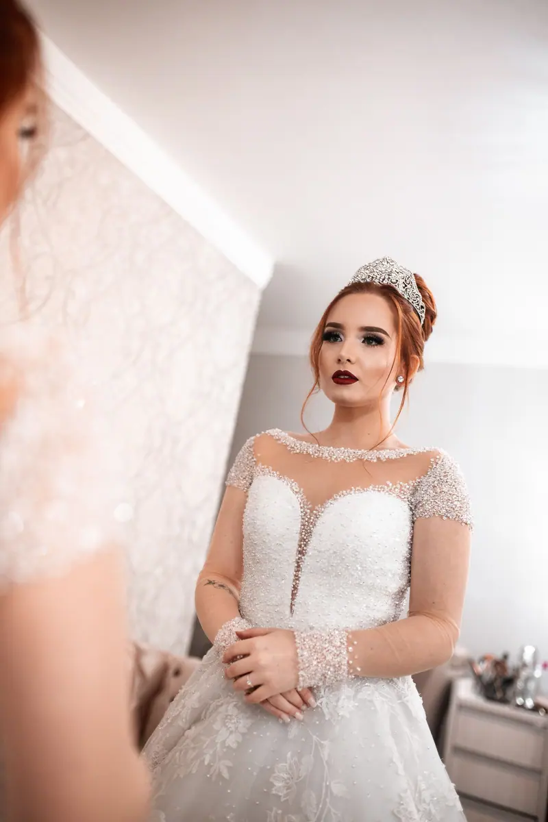 A bride in a stunning white dress stands in anticipation, showcasing elegance and beauty.