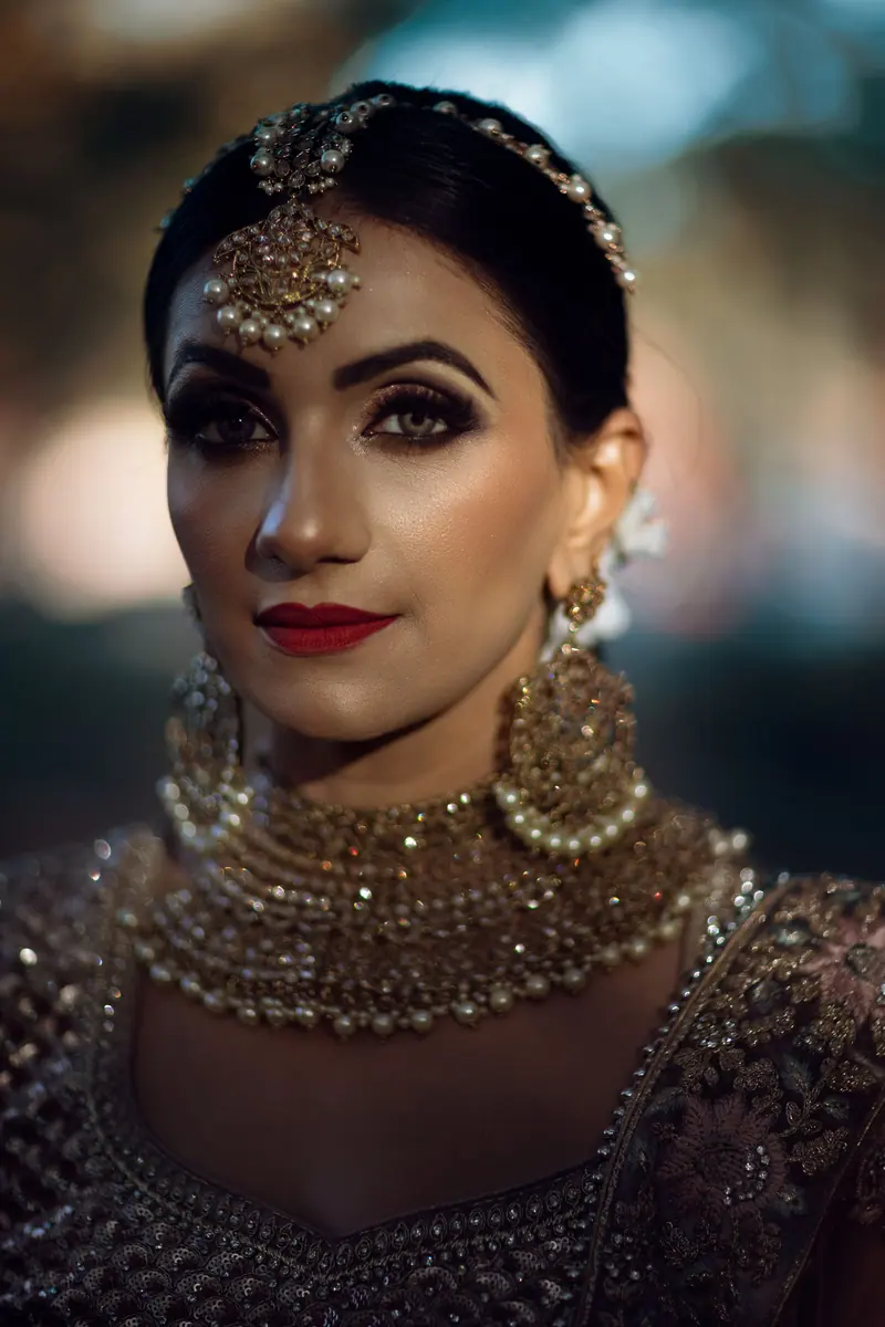 Stunning portrait of a woman in intricate traditional attire with ornate jewelry and vibrant makeup.