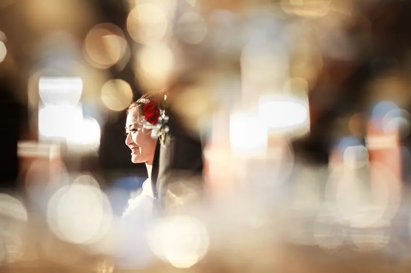 A captivating image of a smiling woman with flowers in her hair, against a dreamy bokeh background.
