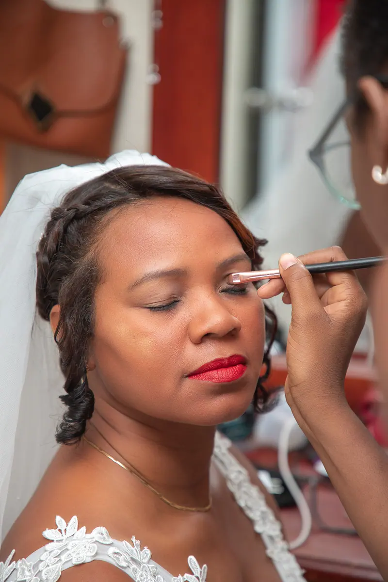 Close-up portrait of a bride having makeup applied, highlighting elegance and beauty.