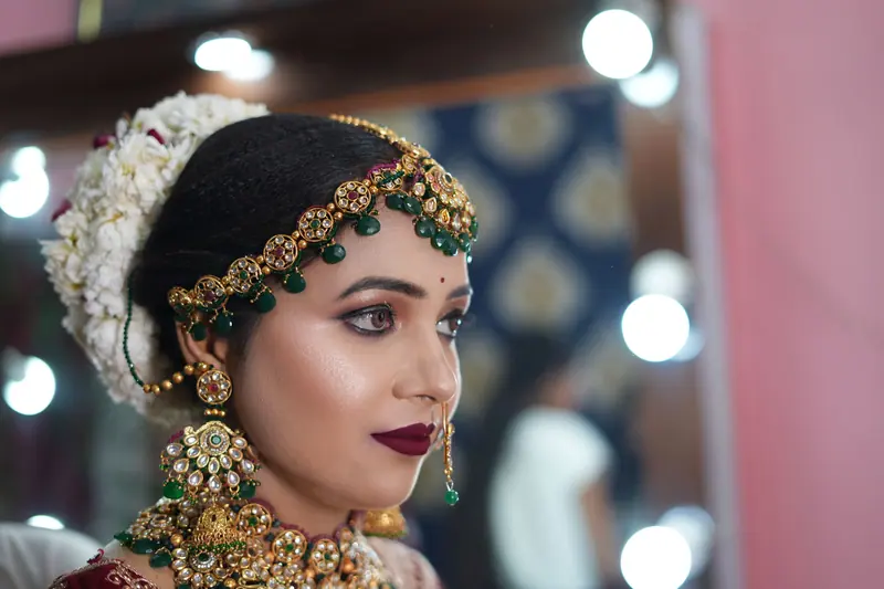 Stunning Indian bride in traditional attire with exquisite jewelry and makeup.